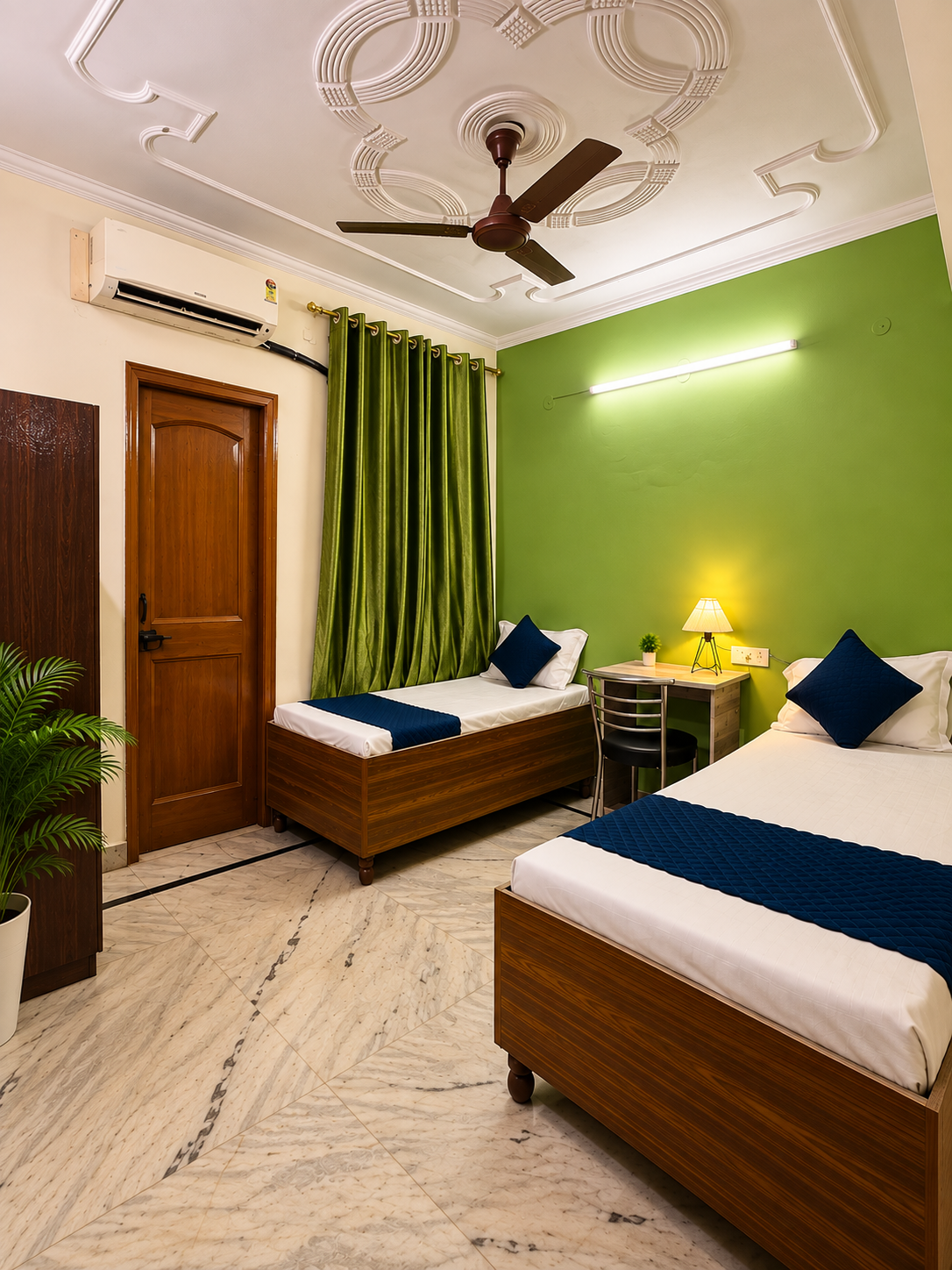Double sharing PG room with two beds, AC, study desk and green accent wall at Serenity PG in Sector 126 Noida